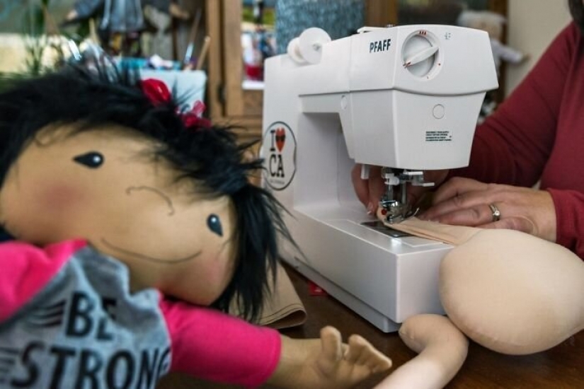 Mujer cose una muñeca especial para niños con discapacidades Mujer cose una muñeca especial para niños con discapacidades