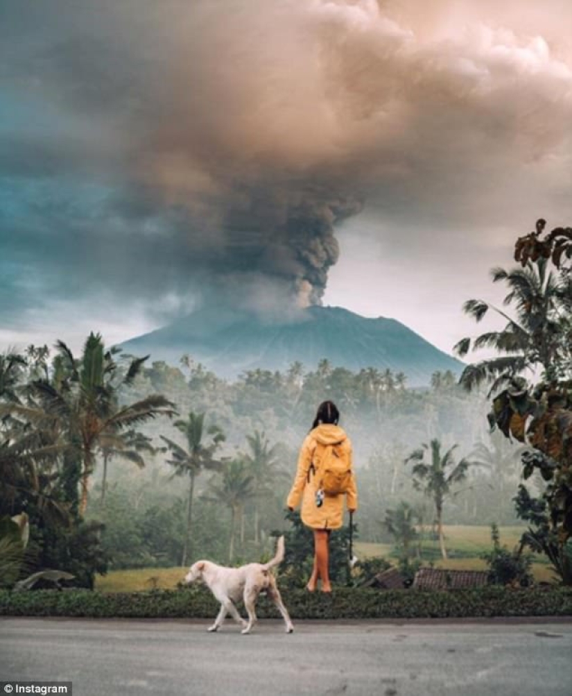 Mientras los residentes de Bali se alejan del volcán, los turistas son fotografiados con el telón de fondo de las emisiones de cenizas Mientras los residentes de Bali se alejan del volcán, los turistas son fotografiados con el telón de fondo de las emisiones de cenizas