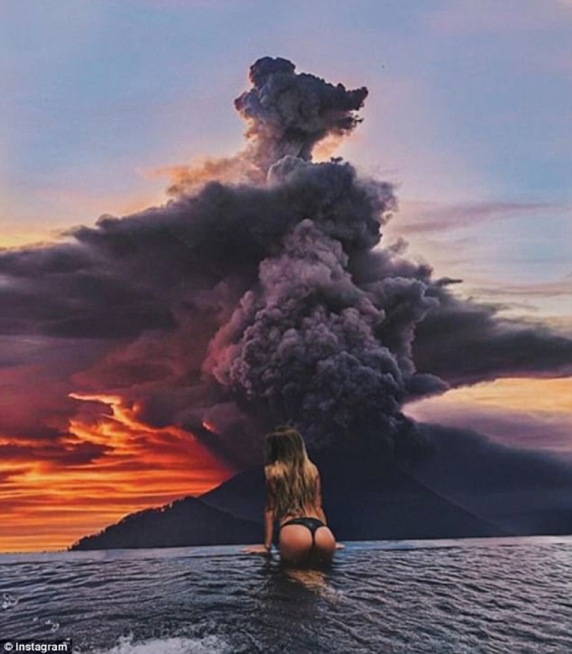 While the residents of Bali are moving away from the volcano, tourists are photographed against the background of ash emissions