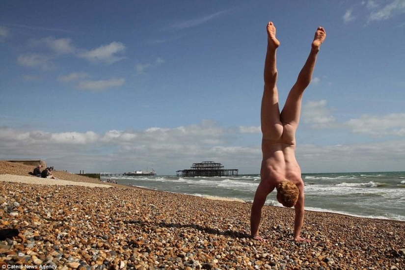 An exhibitionist traveler takes a naked photo against the backdrop of nature and city attractions