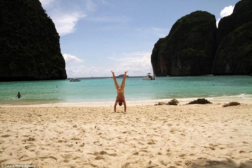 An exhibitionist traveler takes a naked photo against the backdrop of nature and city attractions