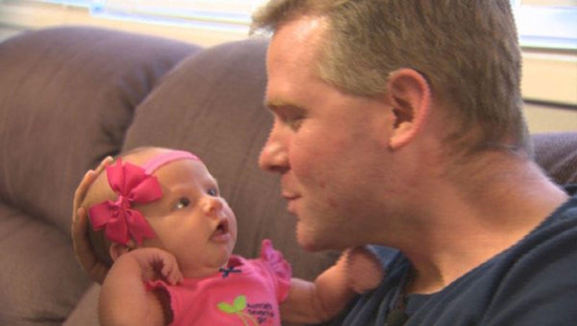 Apple from an apple tree: a young father is photographed with a newborn daughter