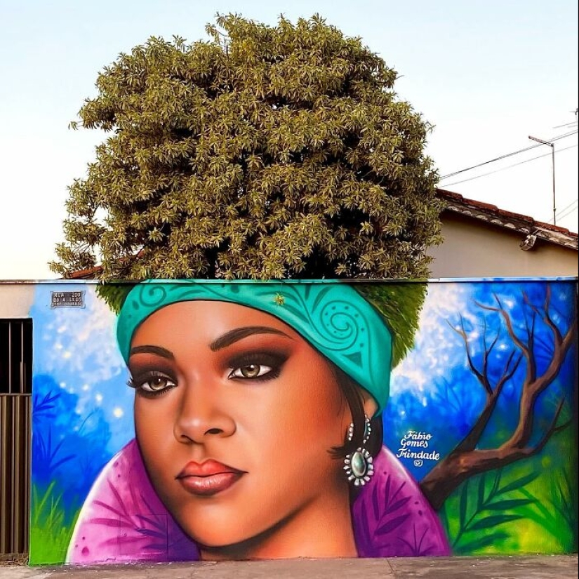 Artista callejero continúa pintando retratos en paredes junto a árboles que también sirven como cabello Artista callejero continúa pintando retratos en paredes junto a árboles que también sirven como cabello