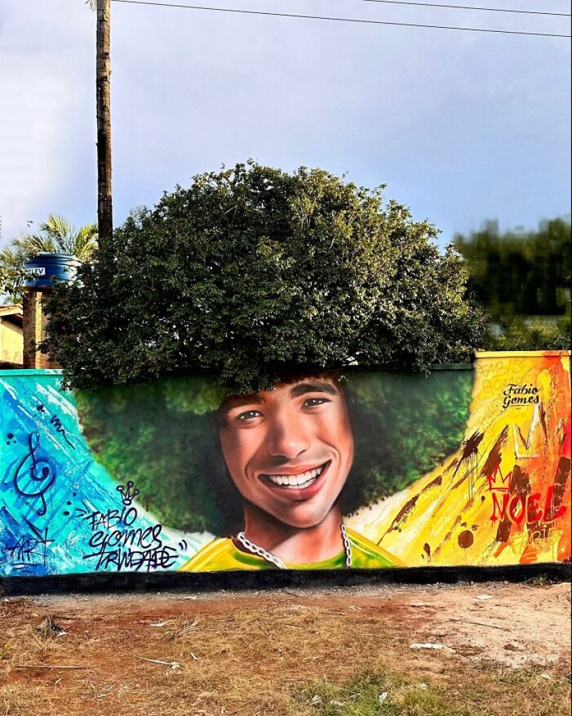 Artista callejero continúa pintando retratos en paredes junto a árboles que también sirven como cabello Artista callejero continúa pintando retratos en paredes junto a árboles que también sirven como cabello