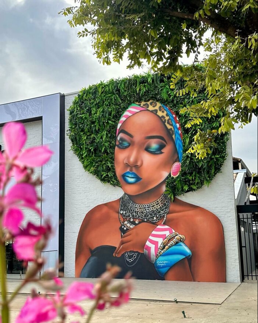 Artista callejero continúa pintando retratos en paredes junto a árboles que también sirven como cabello Artista callejero continúa pintando retratos en paredes junto a árboles que también sirven como cabello