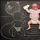 Mom takes a picture of the baby on the "Adventure Board"