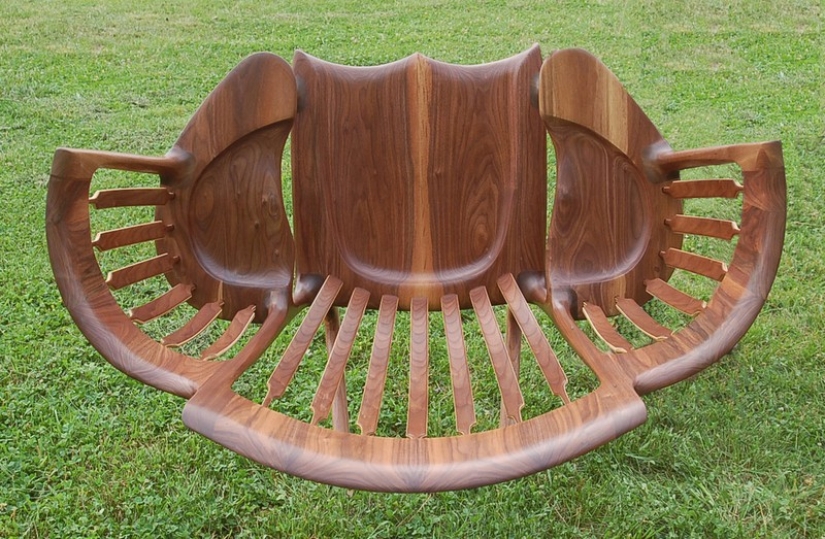 The father created a triple rocking chair to read fairy tales to his children The father created a triple rocking chair to read fairy tales to his children