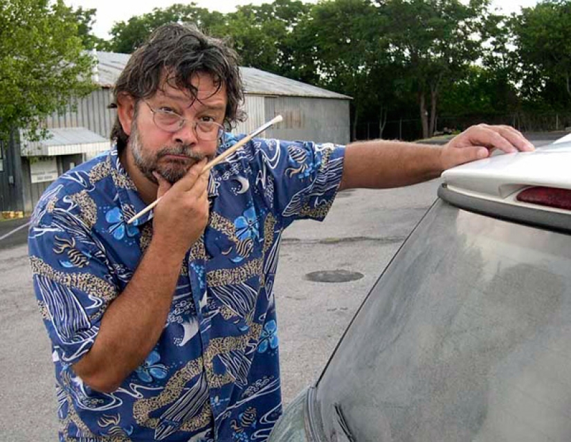 Trabajo polvoriento: el artista pinta pinturas geniales en ventanas sucias de automóviles