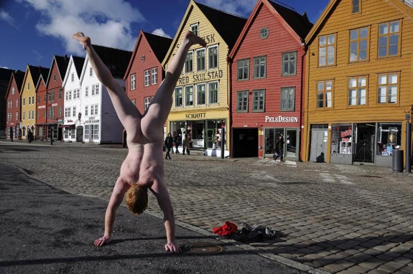 Un viajero exhibicionista se toma una foto desnuda con el telón de fondo de la naturaleza y las atracciones de la ciudad.