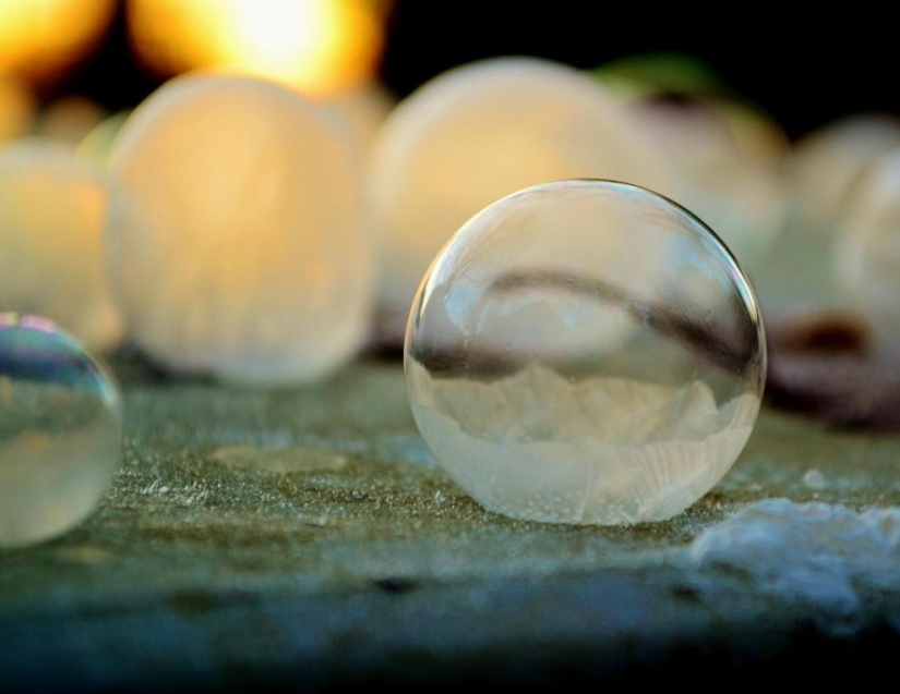 Bolas de cristal - una niña fotografía pompas de jabón en el frío Bolas de cristal - una niña fotografía pompas de jabón en el frío