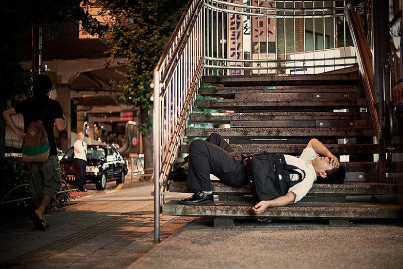 Residentes exhaustos de Tokio durmiendo en la calle