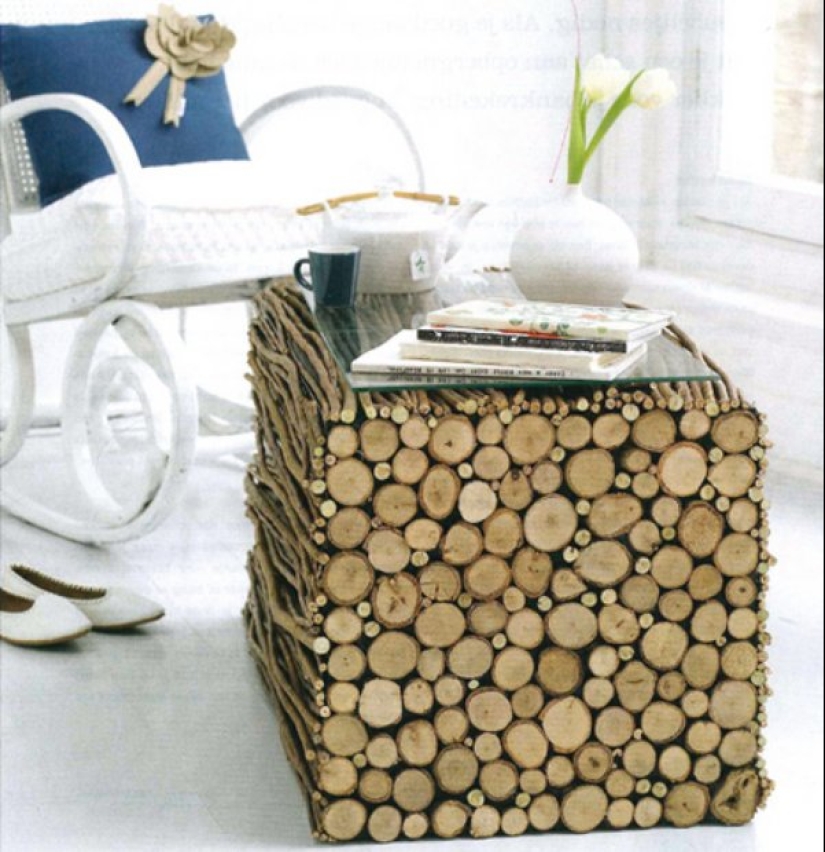 There is grass in the yard, firewood on the grass