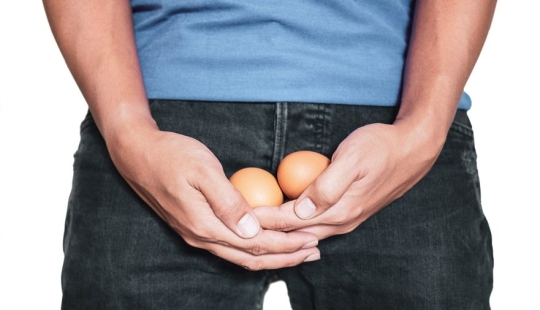 Why do men have one testicle lower than the other and is it normal