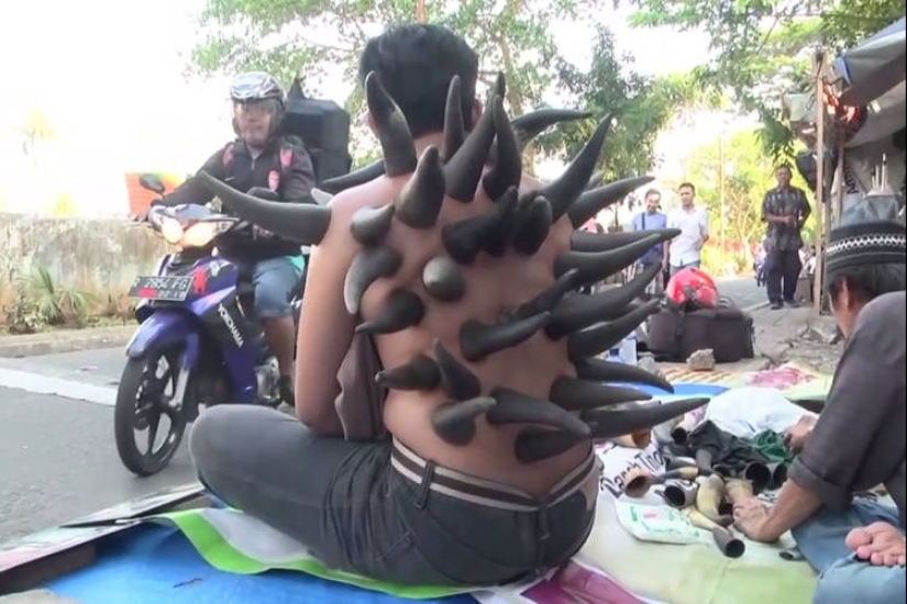 Why do street healers put horns on patients' backs in Indonesia